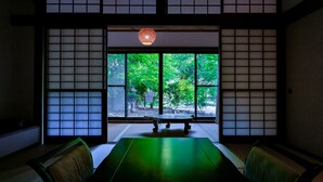 Une pièce de style japonais traditionnel, avec un sol recouvert de tatamis, une table basse et des paravents en papier de riz (shoji).