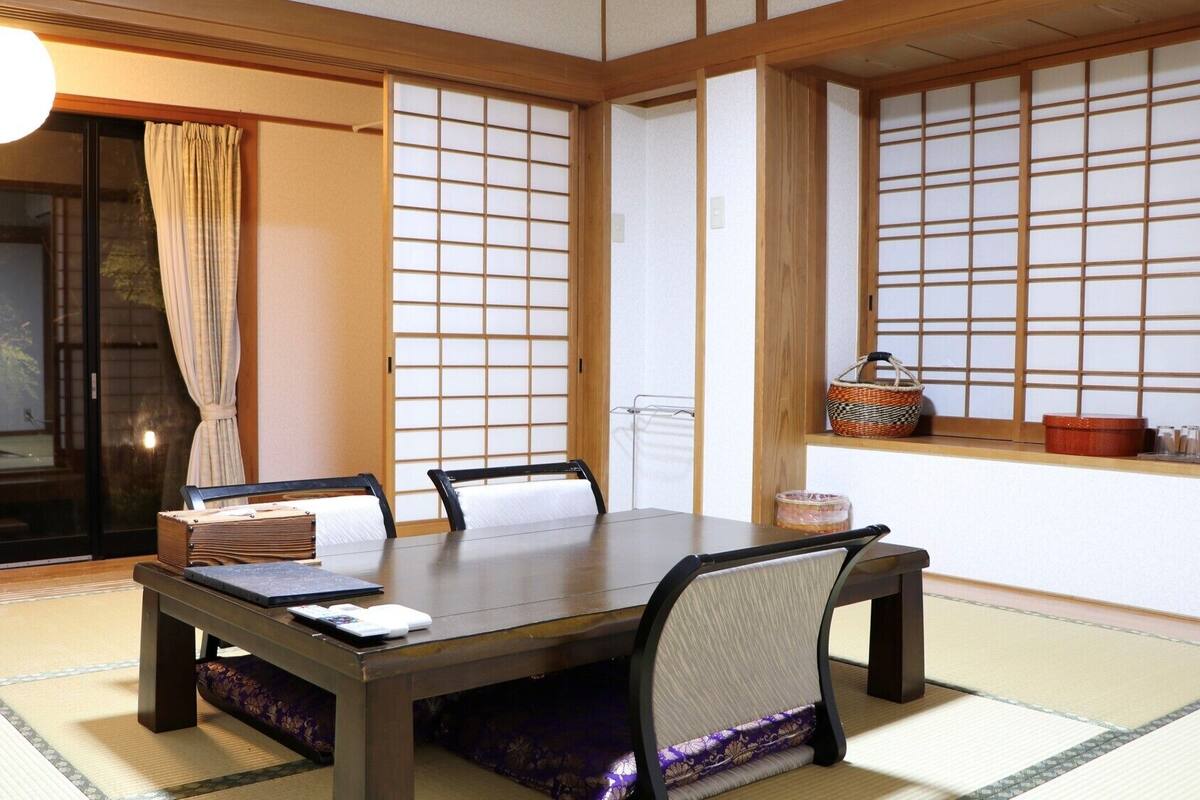 Een traditionele Japanse kamer met tatami vloerbedekking, een lage tafel en schuifdeuren.