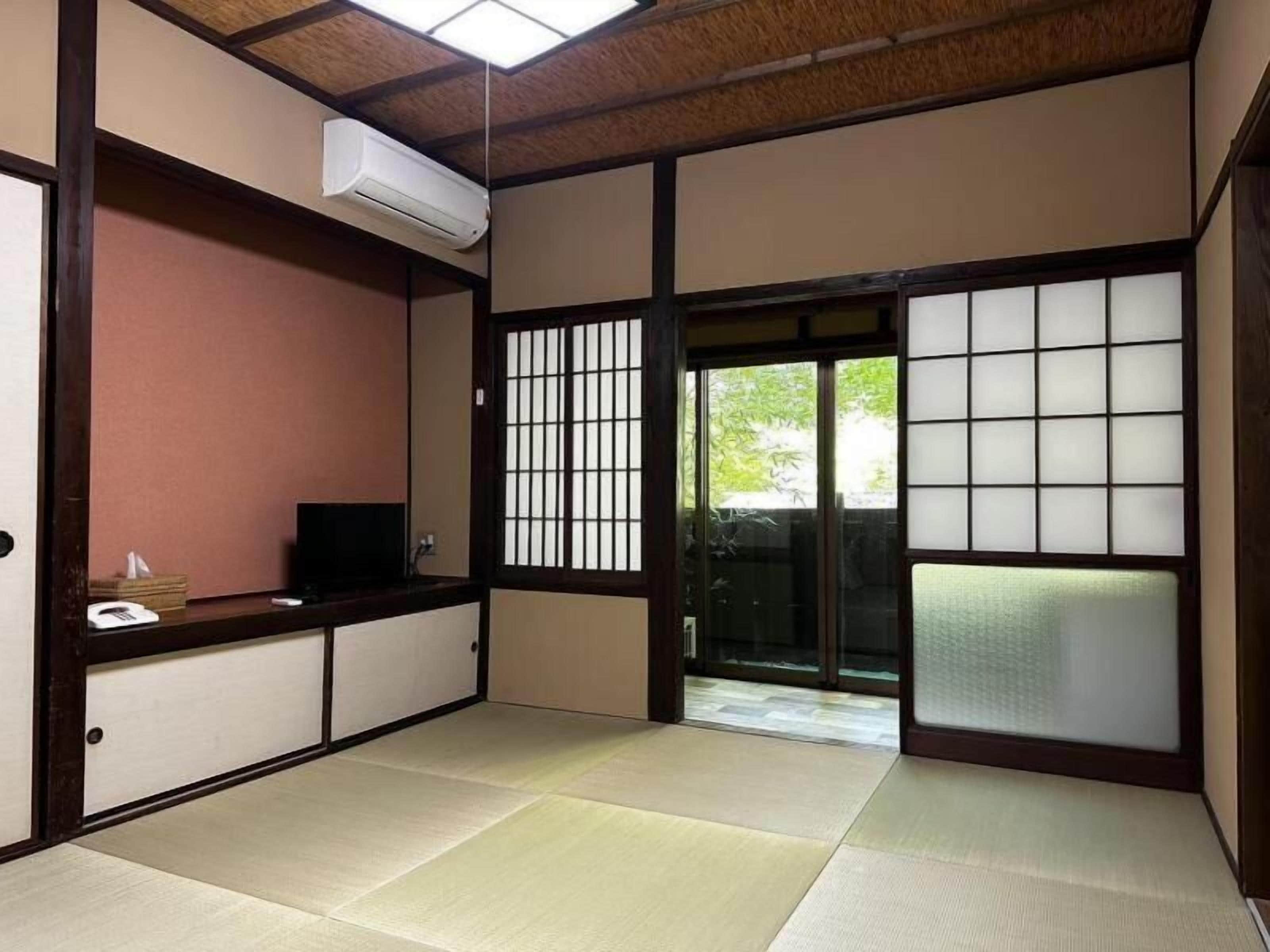 Ein traditioneller japanischer Raum mit Tatami-Böden, Schiebetüren und einer eingebauten Klimaanlage.