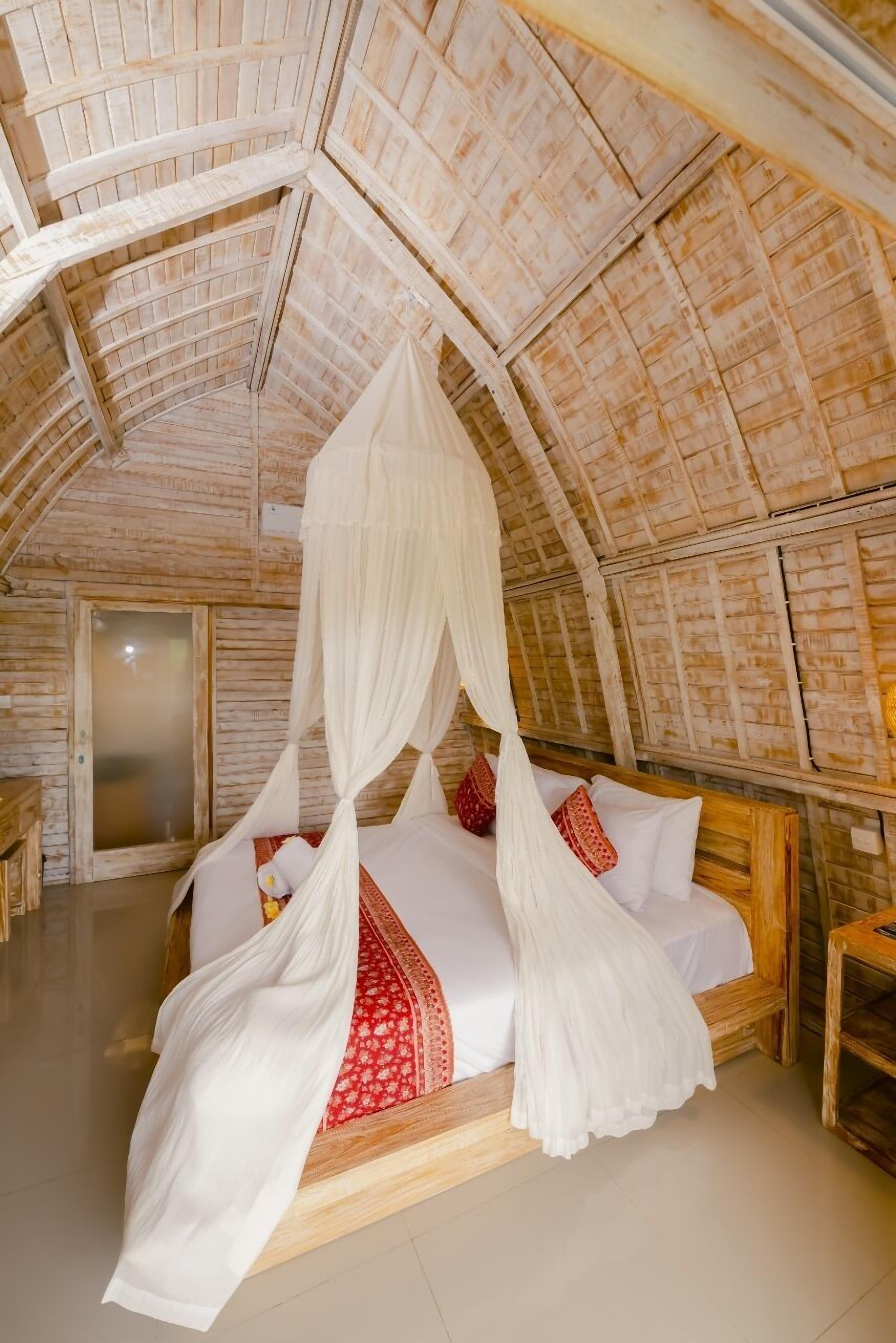 A bedroom with a wooden ceiling, a canopy bed, and a wooden door.