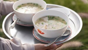 Deux bols de soupe sur un plateau, avec une cuillère.