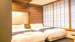 Una camera d'albergo con due letti, un'ampia finestra con stipiti in legno e un moderno design del soffitto.