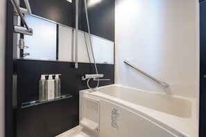 Kombinasi shower/bathtub, pengering rambut, sandal, dan handuk