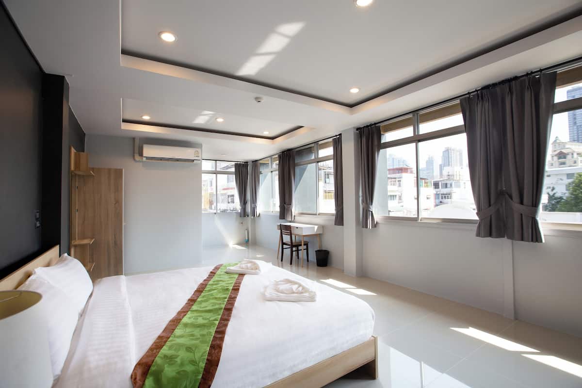 Une chambre d’hôtel moderne avec un grand lit, un bureau et une vue sur la ville.