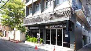 Un bâtiment moderne sur lequel on peut lire l’inscription « 185@SURAWONG ».