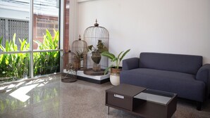 Un salon moderne avec un canapé bleu, une table basse en verre et des cages à oiseaux décoratives.