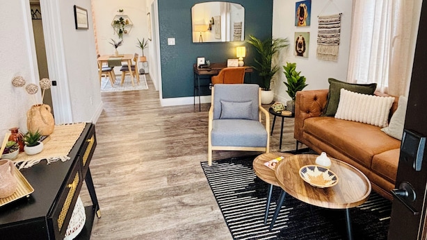 A living room with a sofa, armchair, coffee table, and a dining area with a table and chairs. - Kit Carson Bungalow: AC/Heat + Pets Free! (Trinidad)