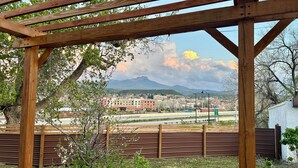 A wooden pergola structure with a view of a cityscape and mountains in the background. - Kit Carson Bungalow: AC/Heat + Pets Free! (Trinidad)