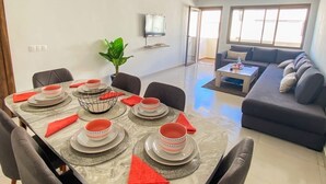 Zona de menjador amb taula de marbre preparada per a sis, envoltada de cadires.