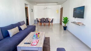 Un saló modern amb un sofà, una taula de centre i una zona de menjador.