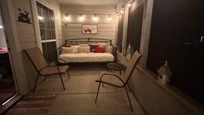 A cozy bedroom with a bed, two chairs, a window, and string lights. - Our Happy Place is located in the gated community of Holly Lake Ranch. (Hawkins)