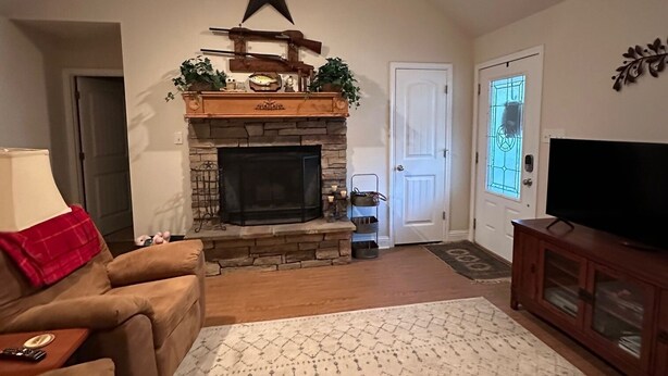 A living room with a fireplace, a television, and a couch. - Our Happy Place is located in the gated community of Holly Lake Ranch. (Hawkins)