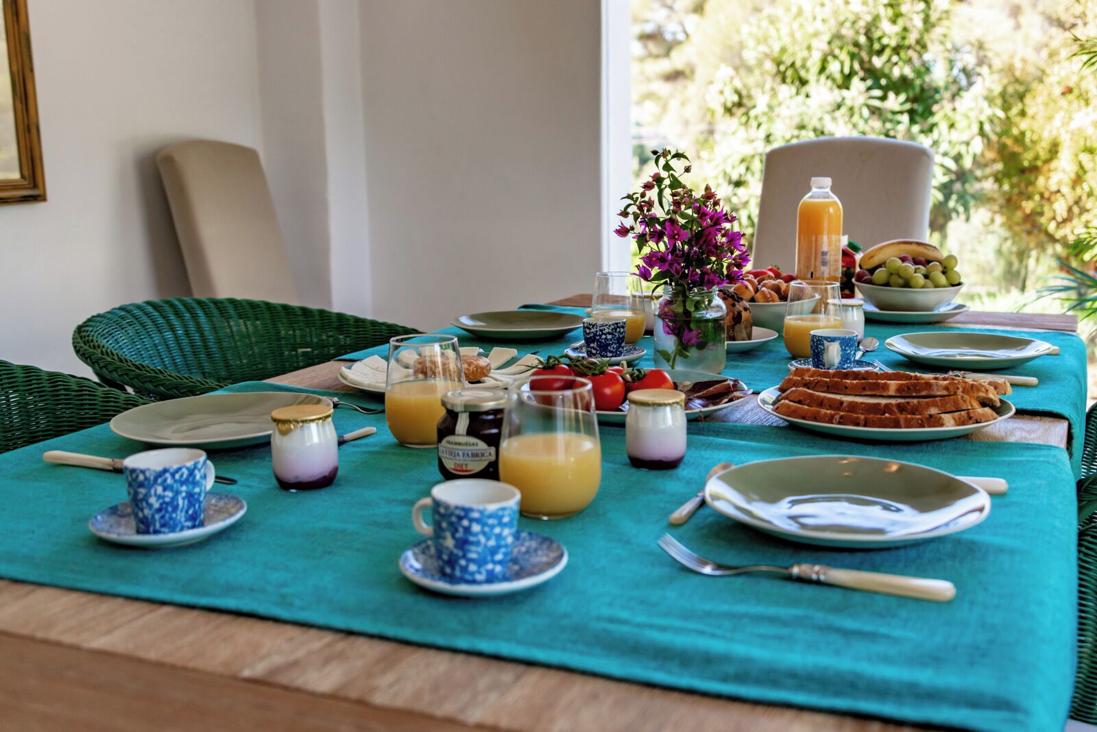 Una tavola apparecchiata per la colazione, con piatti, bicchieri e diversi cibi.
