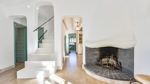 Een modern interieur met een trap, een open haard en een keukenhoek.