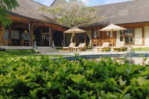 A resort with a pool, lounge chairs, and a covered patio area.