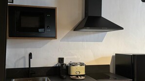 A kitchen with wooden cabinets, a microwave, a stove, and a sink.