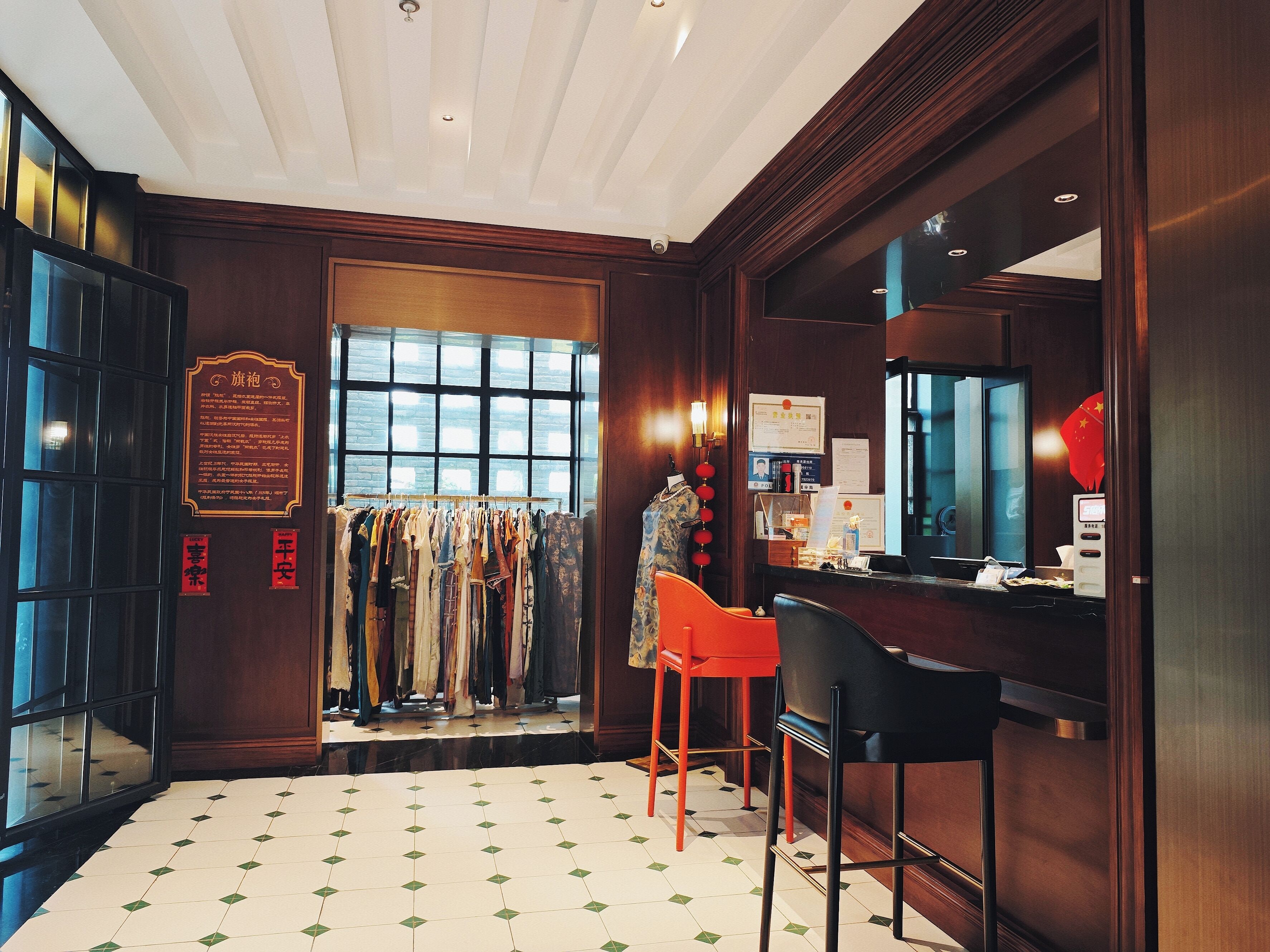 A hotel lobby with a clothing rack, a bar area, and a large window.