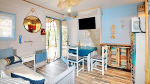 Une pièce comprenant un lit, un bureau et une chaise. Il y a un téléviseur accroché au mur et une fenêtre.