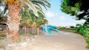 Un parc aquatique doté de nombreux toboggans et de palmiers.