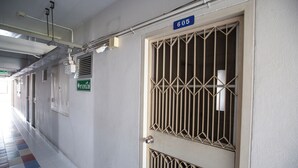 Ein Flur mit einer Tür mit der Aufschrift 605, einem gefliesten Boden und einem grünen Schild an der Wand.