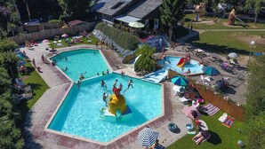 A large outdoor swimming pool with multiple lanes, surrounded by lounge chairs and umbrellas. - Luxury Sunshine Tent in Dochamps (Manhay)