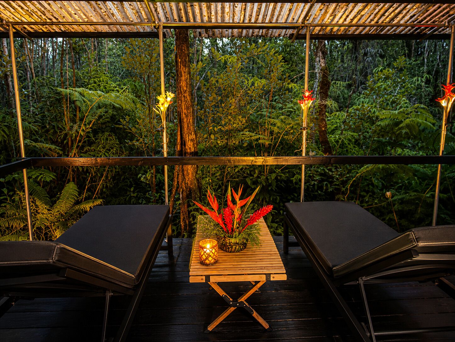 An outdoor seating area with a table and chairs, surrounded by lush greenery.