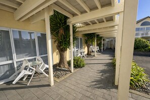 Un espacio al aire libre techado con sillas y una palmera.