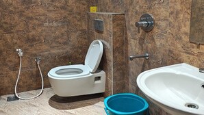 A bathroom with a toilet, bidet, shower, and sink. - The Cloud Hotel (Puducherry)