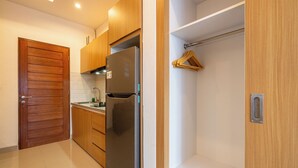 A modern kitchen with wooden cabinets, a stainless steel refrigerator, and a white countertop.