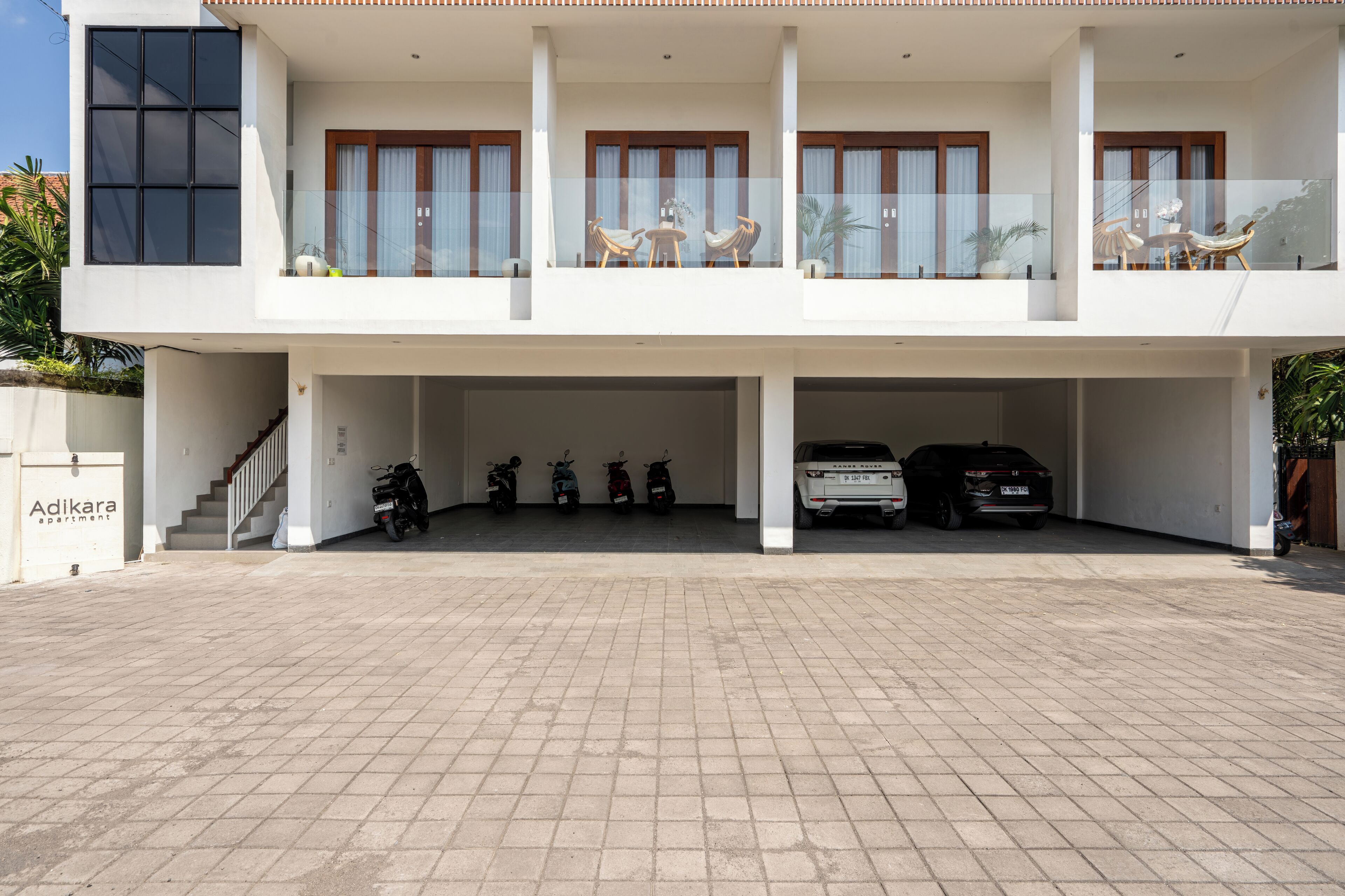 Um edifício de dois andares com área de estacionamento coberta.