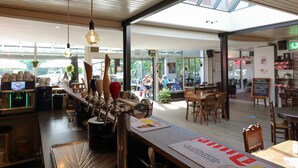 A modern bar area with a long counter, multiple taps, and a menu.