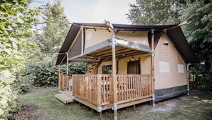 A wooden cabin with a balcony, a staircase, and a covered porch.