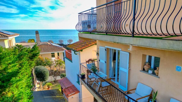 A multi-story building with a balcony overlooking a body of water. - ROSA DELS VENTS: Very central apartment in l'Escala (L'Escala)