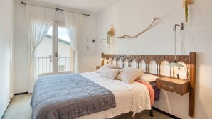 A bedroom with a bed, a nightstand, a lamp, and a wall-mounted shelf. - ROSA DELS VENTS: Very central apartment in l'Escala (L'Escala)