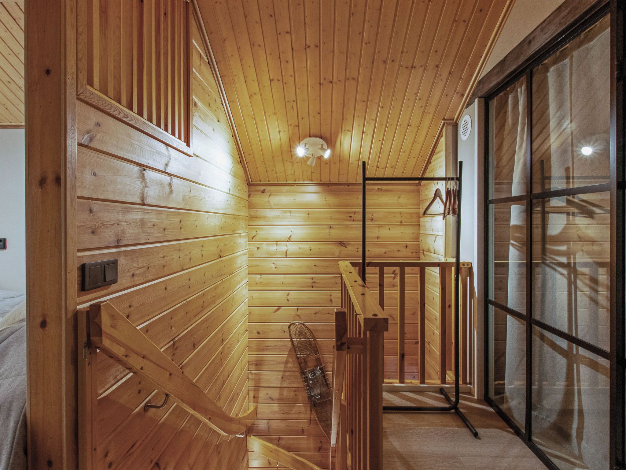 Un interno in legno con una panca, una ventola a soffitto e una porta in vetro.