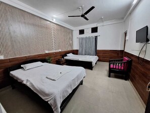 A hotel room with two beds, a ceiling fan, a TV, and a wooden accent wall. - Hotel High East (Papumpare)
