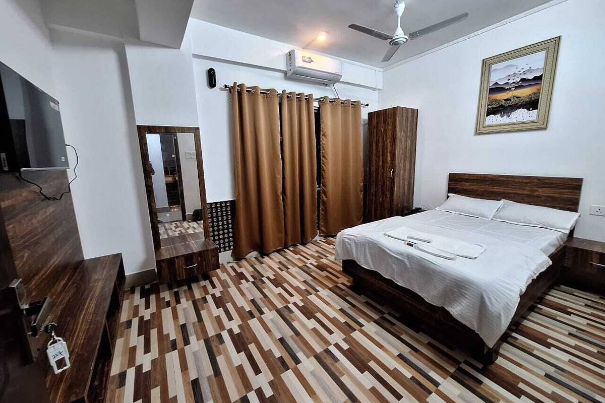 Ein Schlafzimmer mit Bett, Kleiderschrank, Spiegel und Deckenventilator.