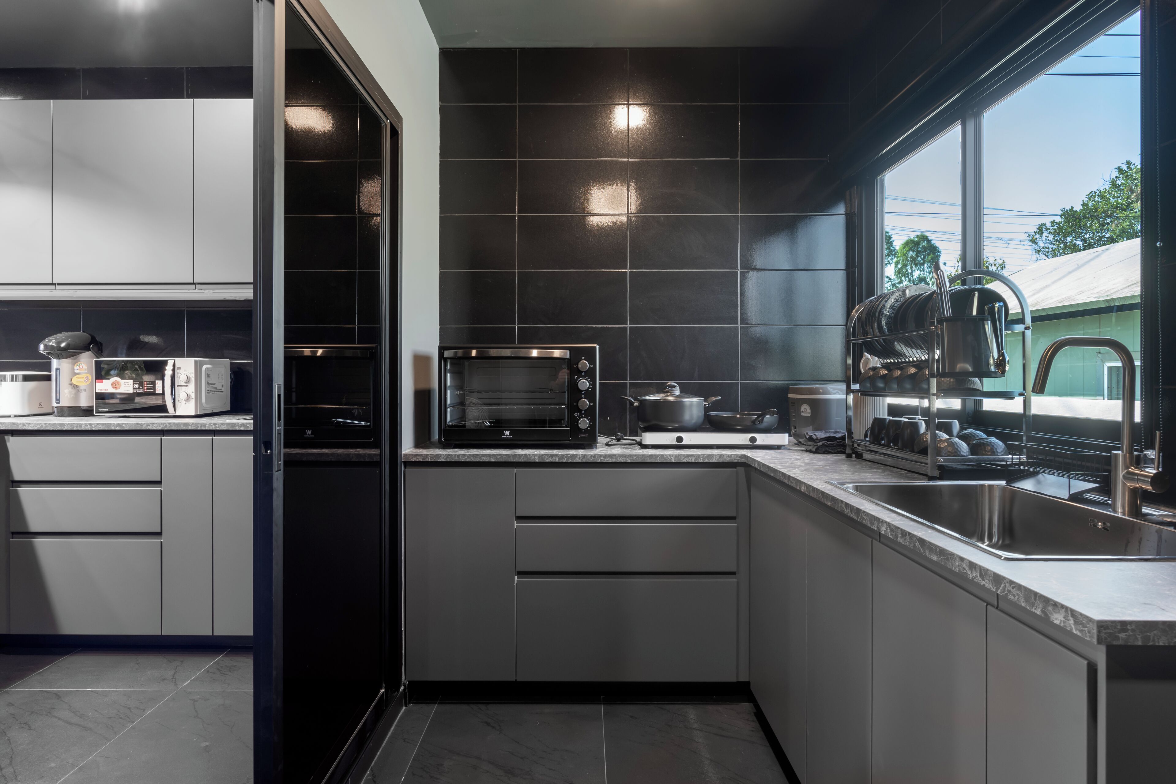 Cocina moderna equipada con microondas, horno y escurreplatos.