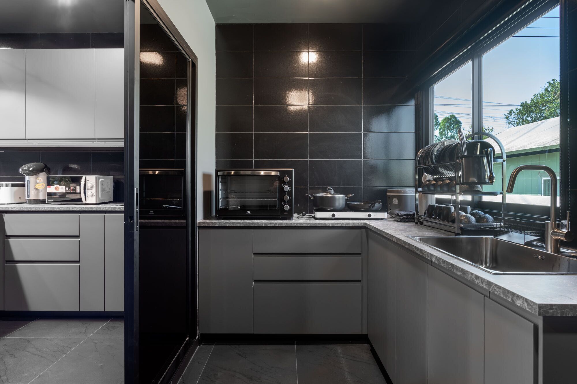 Una cocina moderna con electrodomésticos integrados, un ventanal y vistas al exterior.