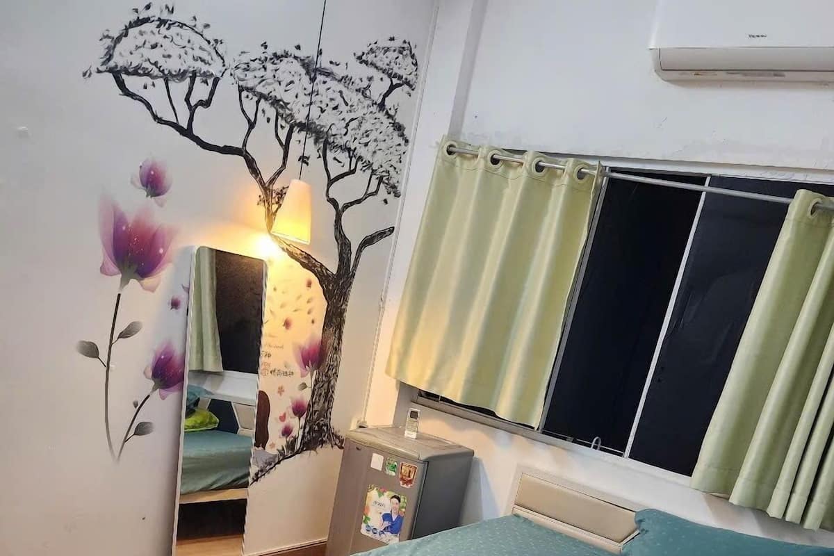 Un dormitorio con cama, espejo, cómoda y un mural en la pared.