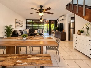 Une cuisine moderne avec un coin repas, un ventilateur de plafond et une vue sur l’extérieur.