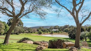 A park with trees, a pond, and a distant hill. - Petra Olive 3 (Yallingup)