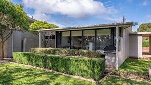 A modern house with a covered patio, a neatly trimmed hedge, and a clear sky. - Petra Olive 3 (Yallingup)