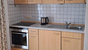 Cafetera o tetera, frigorífico, horno y placa de cocina