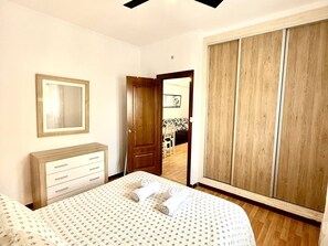 A bedroom with a bed, a dresser, a wardrobe, and a mirror. - Los 3 hermanos by Staycare (Rota)