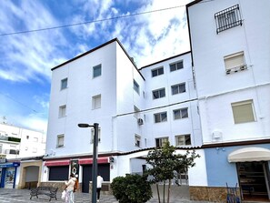 Un edificio de varios pisos con fachada plana, varias ventanas y una entrada visible.