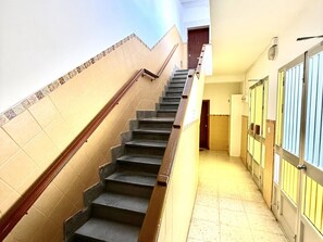 Una escalera con barandilla que lleva a una puerta al final.