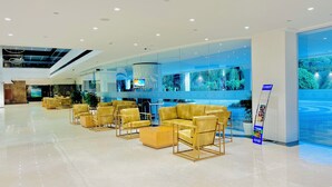 A modern lobby with a seating area, a reception desk, and a large digital screen. - Gokulam Grand Kozhikode (Kozhikode)