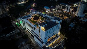 A modern hotel with a rooftop pool, a central courtyard, and a well-lit facade. - Gokulam Grand Kozhikode (Kozhikode)