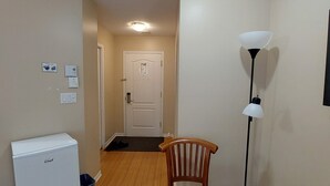 A compact living space with a kitchenette, a wooden chair, a small table, and a standing lamp. - Cozy studio in nice Piedmont with AC, WiFi, parking, kitchenette (Piedmont)